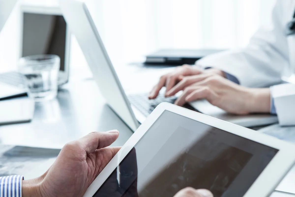 Enterprise-Team bei der Arbeit mit Tablet und Laptop